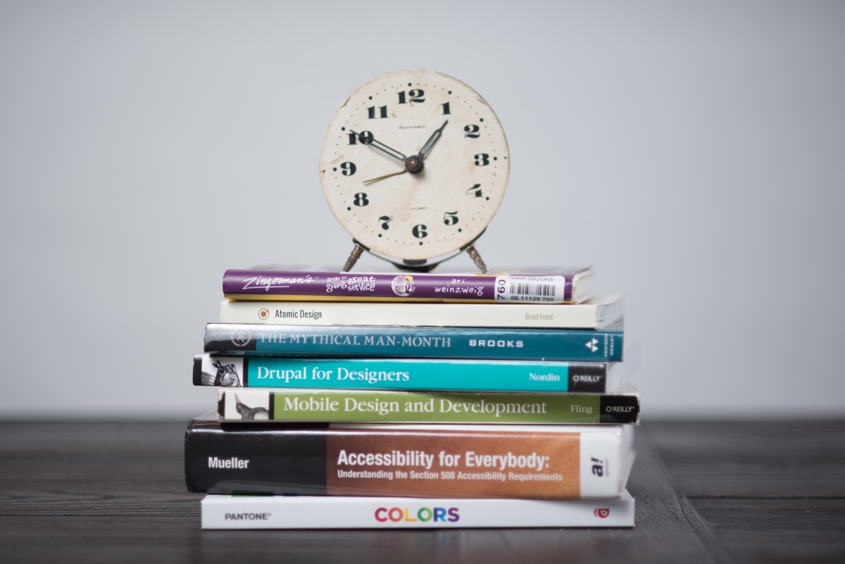 An analog clock atop a stack of the Gravity Works team's favorite books